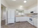 Spacious kitchen featuring white appliances and cabinets with durable wood-look flooring at 15388 Dry Creek Rd, Noblesville, IN 46060