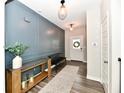 Inviting entryway featuring a stylish console table, decorative wall paneling, and modern light fixtures at 17390 Tribute Row, Noblesville, IN 46060
