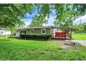 Relaxing backyard with a covered deck area for outdoor living and entertaining amidst mature trees at 217 W Burnside Ave, Fairland, IN 46126