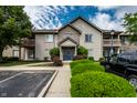 Well-maintained condo building with manicured landscaping and visible parking spots on a sunny day at 246 Legends Creek Way # Apt 207, Indianapolis, IN 46229