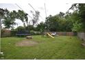 Spacious backyard with a trampoline, playset, and lush lawn, perfect for Gathering fun and recreation at 2638 S Mcclure St, Indianapolis, IN 46241