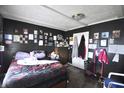 Cozy bedroom with dark walls, wood floor, with pictures displayed and natural light filtering through at 2638 S Mcclure St, Indianapolis, IN 46241