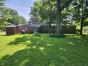 Expansive backyard with mature trees, a storage shed, and a brick home exterior at 2808 Woodside Dr, Plainfield, IN 46168