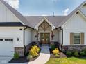 Home's inviting front entrance with detailed trim, a peaked roof and elegant landscaping at 320 Briar Hill Dr, Whiteland, IN 46184