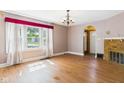 Bright living room featuring hardwood floors, a brick fireplace, and large windows with valance at 328 Marine Dr, Anderson, IN 46016