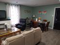 Open-concept living room with modern furnishings, including a dining table and comfortable seating at 3330 S Mooresville Rd, Indianapolis, IN 46221