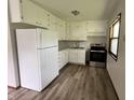 Efficient kitchen features white cabinetry, updated appliances, and luxury vinyl plank flooring at 3525 Lombardy Pl, Indianapolis, IN 46226