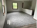 Bright living room featuring neutral walls, new carpet and natural light from large windows at 3525 Lombardy Pl, Indianapolis, IN 46226