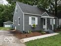Side view of a quaint one-story home featuring grey siding and a detached garage at 4405 Primrose Ave, Indianapolis, IN 46205