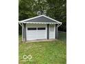 Detached one-car garage with white door and matching trim, nestled in a green yard at 4405 Primrose Ave, Indianapolis, IN 46205