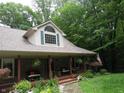 Inviting home with a spacious porch, brick facade, hanging plants, and beautiful landscaping at 4521 Tulip N Dr, Martinsville, IN 46151