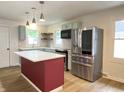 Well-lit kitchen features a center island, stainless steel appliances, and modern pendant lighting at 5115 Primrose Ave, Indianapolis, IN 46205