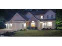 Two-story home with a brick facade and white siding, featuring a well-maintained lawn at dusk at 6483 Timber Walk Dr, Indianapolis, IN 46236