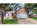 Charming brick home featuring an attached two-car garage, manicured lawn, and mature trees at 6640 Chipping Ct, Indianapolis, IN 46268