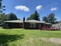 Expansive backyard featuring a well-maintained lawn, mature trees, and a cozy deck for outdoor enjoyment at 7725 S Oak Dr, Indianapolis, IN 46227
