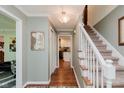 Inviting hallway leading to the staircase, featuring elegant decor and warm lighting at 8201 Castle Dr, Indianapolis, IN 46256