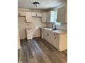 Well-lit kitchen with white cabinets, granite countertops, stainless steel faucet, and wood flooring at 8434 Meadowlark Dr, Indianapolis, IN 46226