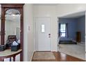 Inviting foyer featuring hardwood floors, a charming mirror, and access to living areas at 8778 N Deer Crossing Blvd, McCordsville, IN 46055
