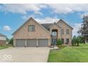 Charming brick two-story home with a well-manicured lawn and a three-car garage at 1035 White Oak Dr, Plainfield, IN 46168