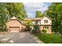 Traditional two-story home featuring a brick facade, a well-maintained lawn, and mature trees at 10518 Courageous Dr, Indianapolis, IN 46236