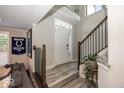 Inviting foyer featuring a staircase with wood and metal railing, stylish decor, and a view of the front door at 13301 Minden Dr, Fishers, IN 46037