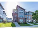 Modern townhomes feature brick and metal siding, landscaped lawns and entryways with concrete steps at 13301 Minden Dr, Fishers, IN 46037