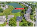 Aerial view of a suburban home nestled beside a tranquil pond and surrounded by lush greenery and neighborhood homes at 14052 Rayners Ln, Fishers, IN 46037