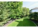 View of a backyard with manicured lawn, a fence and lush landscaping, creating a serene and private outdoor space at 14082 Brazos Dr, Carmel, IN 46033