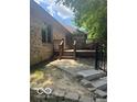 Exterior view of the home's backyard featuring a raised deck, access stairs, and mature trees at 1456 Bent Tree Pl, Greenwood, IN 46143