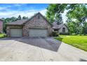 A single-story brick home with a three-car garage, a well-kept lawn, and a paved driveway at 1456 Bent Tree Pl, Greenwood, IN 46143