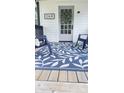 Cozy porch showcasing chairs, a leaf pattern rug, and a door with a wreath on a beautiful home at 249 N Mill St, Plainfield, IN 46168