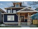 Beautiful two story home features a dark blue exterior, stone accents, covered porch, and well-maintained landscaping at 3054 Ruckle St, Indianapolis, IN 46205