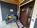 Cozy front porch boasts comfortable seating, a welcome mat, and the house number on the door frame at 3054 Ruckle St, Indianapolis, IN 46205