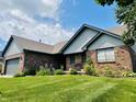 Charming single-story home with a brick exterior, a well-manicured lawn and a two car garage at 3418 S Rosewind Dr, New Palestine, IN 46163