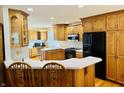 Spacious eat-in kitchen featuring oak cabinets, sleek black appliances, and counter seating for two at 3418 S Rosewind Dr, New Palestine, IN 46163