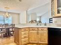 Charming kitchen with light oak cabinets and granite countertops, adjoining dining area with chandelier at 3418 S Rosewind Dr, New Palestine, IN 46163