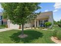 Beautifully landscaped front yard featuring a manicured lawn, decorative trees, and a charming entrance with bench seating at 3420 Stoddard Pl, Indianapolis, IN 46217
