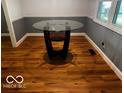 Dining room featuring hardwood floors, two-tone walls, and a glass-top dining table at 3815 Briar Rdg, Monrovia, IN 46157