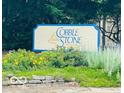 Cobblestone community sign surrounded by lush greenery and flowers in a serene setting at 4609 Framington Ct, Indianapolis, IN 46254