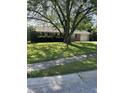 A traditional brick home with lush green lawn, mature trees and an attached two-car garage at 5453 David St, Indianapolis, IN 46226