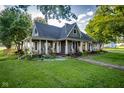 Inviting home with a covered porch, adorned with classic columns and a picturesque landscape at 6012 N 200 W, Greenfield, IN 46140