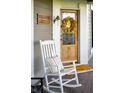 Welcoming front porch showcases a classic rocking chair and decorative wreath on the front door at 6012 N 200 W, Greenfield, IN 46140