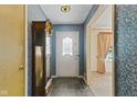 Cozy foyer featuring slate flooring, floral wallpaper, and a classic grandfather clock at 618 Mellowood Dr, Indianapolis, IN 46217