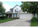 Charming two-story home featuring an attached two car garage and beautiful landscaping at 6422 Hollingsworth Dr, Indianapolis, IN 46268