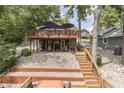 Lake house exterior showcasing a multilevel wooden deck and lakeside access at 6497 Osprey Dr, Nineveh, IN 46164