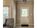 Bright entryway with white door, neutral walls, patterned chair, and tile floors creates a welcoming first impression at 6556 Reserve Dr, Indianapolis, IN 46220