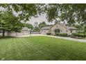 Expansive green lawn featuring a charming stone home with a detached three-car garage and basketball hoop at 6649 Madison Ave, Indianapolis, IN 46227