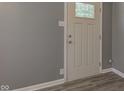 Close-up of an interior white door with a glass window, gray walls, and wood-look flooring at 710 S Bancroft St, Indianapolis, IN 46203