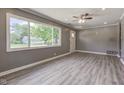 Bright living room featuring large windows, gray walls, recessed lighting, and stylish laminate floors at 710 S Bancroft St, Indianapolis, IN 46203