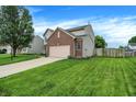 Beautifully maintained home with lush green lawn and mature landscaping at 7215 Braxton Dr, Noblesville, IN 46062